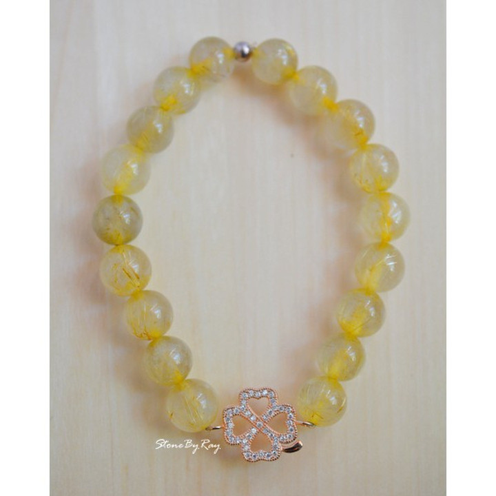 Pulsera de seda dorada con dije de trébol de cuatro hojas